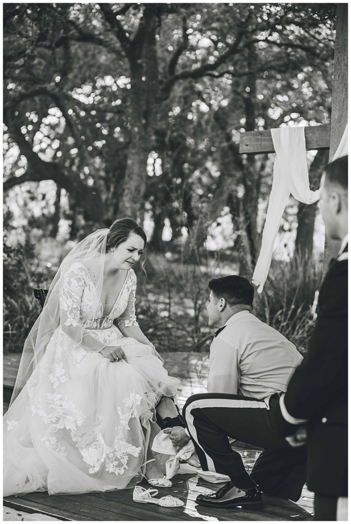 groom washes bride's feet during ceremony