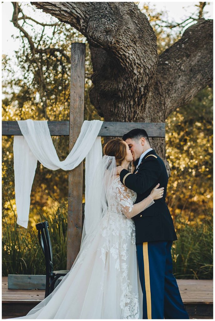 bride and groom kiss during wedding ceremony