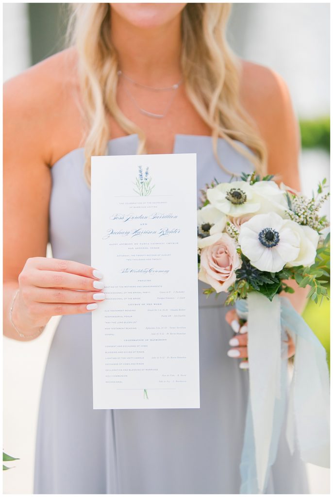 bridesmaid holds up wedding program