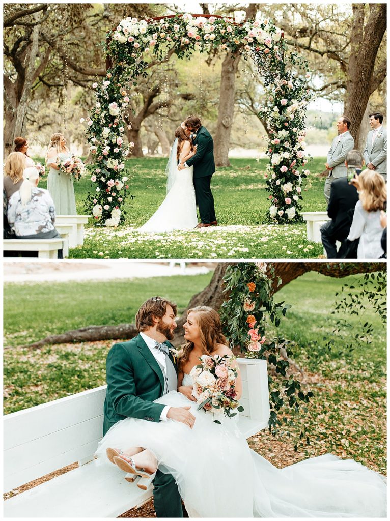 bride and groom stand under flower arch