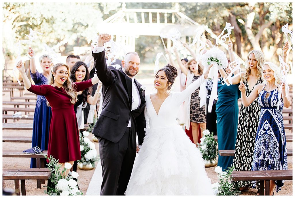 couple cheers with ribbon wands with family