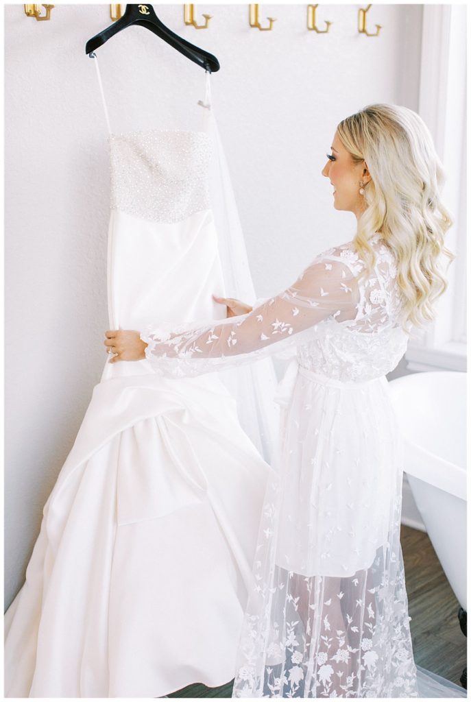 bride admiring wedding gown