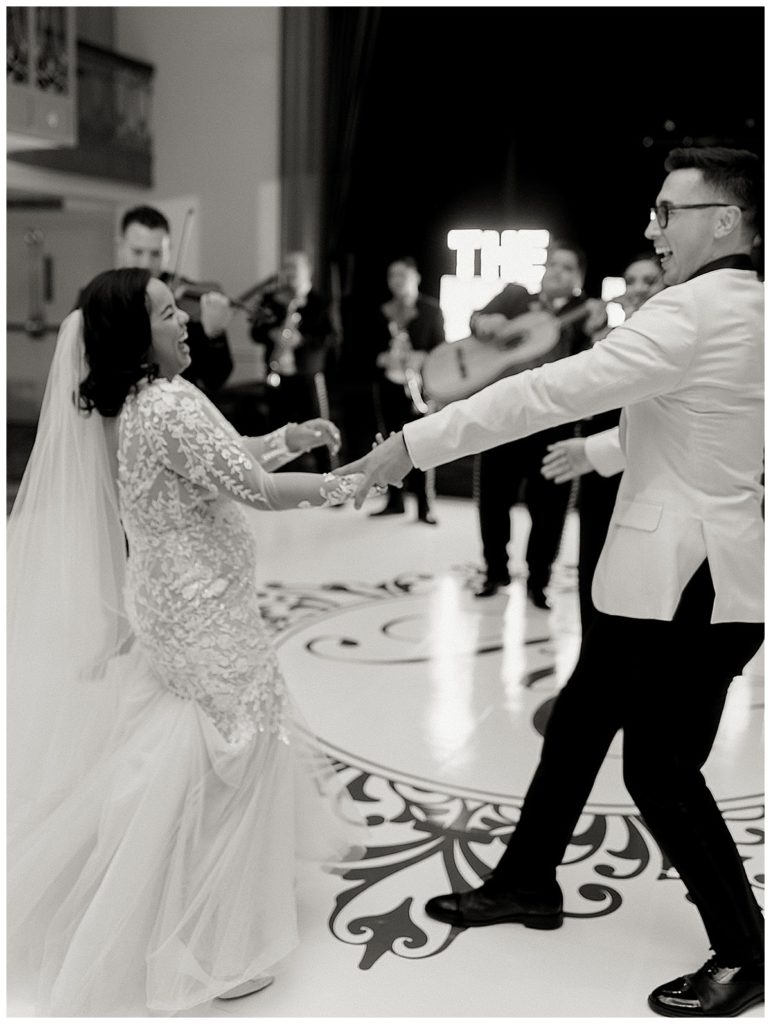 bride and groom dancing and laughing at reception